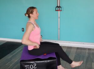 dr. Chloe with a lacrosse ball under her right hamstring working on hamstring flexibility 